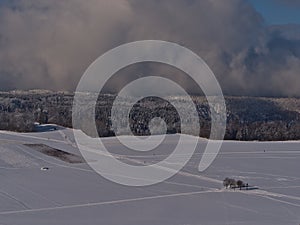 Aerial view of winter landscape with people doing cross-country skiing on snow-covered fields viewed from KornbÃ¼hl hill.