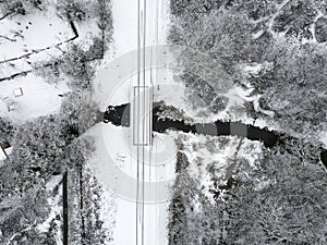 Aerial view of winter landscape with railway crossing the river covered with snow. drone photography. top view