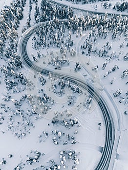 Aerial view of winter road in the forest covered with snow, Finland Lapland