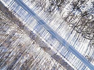 Aerial view of a winter road in the forest. Winter landscape countryside. Aerial photography of snowy forest with road. Captured f