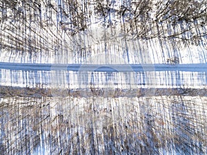 Aerial view of a winter road in the forest. Winter landscape countryside. Aerial photography of snowy forest with road. Captured f