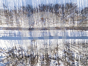 Aerial view of a winter road in the forest. Winter landscape countryside. Aerial photography of snowy forest with road. Captured f