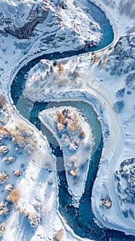 Aerial view. Winter scene of river winding through snow-covered forest. River is frozen and covered in white snow