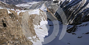 Aerial view of winter slope of Alps with sunny ski pathways  and cable road