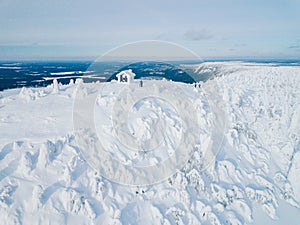 Aerial view of winter snow covered wood hut. Frozen log cabin in Finland