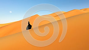Aerial view of a woman in abaya walking in the desert photo