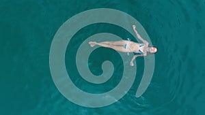 Aerial view of woman relaxing in turquoise water
