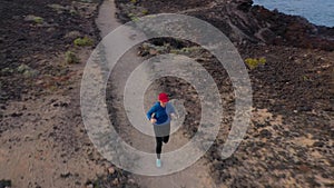 Aerial view of woman runnning along the nature reserve at sunrise. Healthy active lifestyle