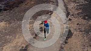 Aerial view of woman runnning along the nature reserve at sunrise. Healthy active lifestyle