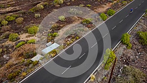 Aerial view of the woman runs along the deserted asphalt road at sunset. Mountains on the background