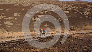 Aerial view of woman runs along the oceanfront nature reserve at sunrise. Healthy active lifestyle