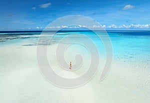 Aerial view of woman, sandbank, white sand, sea in low tide
