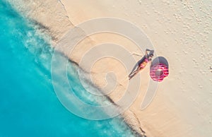 Aerial view of woman with swim ring on the sandy beach