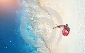 Aerial view of woman with swim ring on the sandy beach