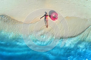 Aerial view of woman with swim ring on the sandy beach