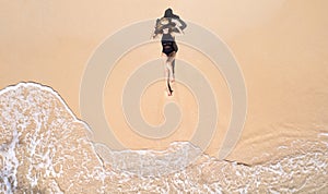 Aerial view, women lounging, sunbathing on the beach and beautiful blue water waves on the island of Thailand