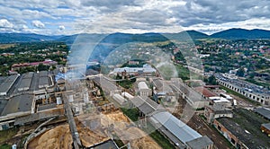 Aerial view of wood processing factory with smoke from production process polluting atmosphere at plant manufacturing