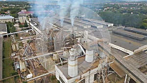 Aerial view of wood processing plant with smokestack from production process polluting environment at factory