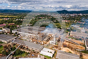 Aerial view of wood processing plant with smokestack from production process polluting environment at factory