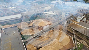 Aerial view of wood processing plant with smokestack from production process polluting environment at factory