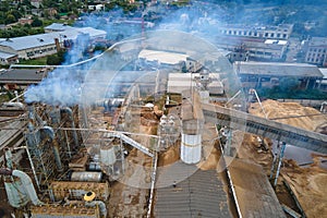 Aerial view of wood processing plant with smokestack from production process polluting environment at factory