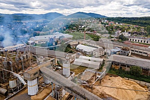 Aerial view of wood processing plant with smokestack from production process polluting environment at factory