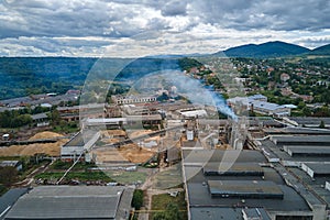 Aerial view of wood processing plant with smokestack from production process polluting environment at factory