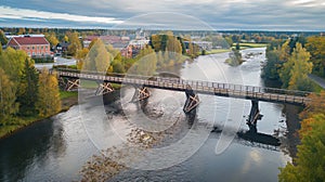 Aerial view of wooden bridge in Sweden. Wooden Lejonstromsbron bridge crosses the river, surrounded by green trees and water. photo