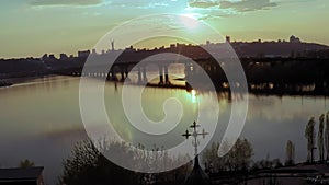 Aerial view of a wooden church with a large golden cross near the wide river Dnieper in Kiev