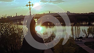 Aerial view of a wooden church with a large golden cross near the wide river Dnieper in Kiev