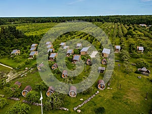 Aerial view of the wooden houses and bungalows in the green field in Hiiumaa