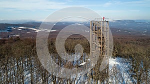 Aerial view of wooden lookout tower on the top of Velka Homola in winter