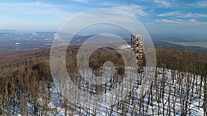 Aerial view of wooden lookout tower on the top of Velka Homola in winter