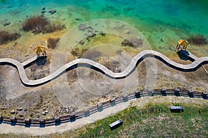 Aerial view of wooden path over turquiose lake colour. Drought. Drone top view