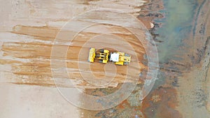 Aerial view of the working earth mover grader flattens the surface