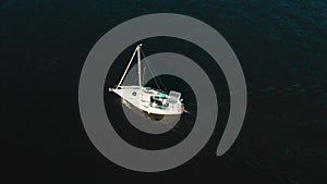 Aerial view of yacht with solar panels sailing sea or river on sunrise