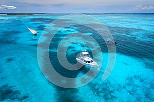 Aerial view of the yachts, fishing boats in clear blue water