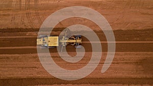 Aerial view yellow excavator building a highway, Road grader heavy earth moving, Bulldozer working at road construction