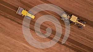 Aerial view yellow excavator building a highway, Road grader heavy earth moving, Bulldozer working at road construction