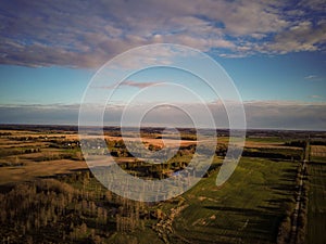 Aerial view of a yellow wheat rye and green corn farm fields going into horizon. Sunny day, blue sky. Agriculture and