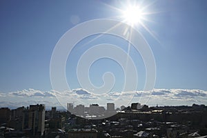 Aerial view of Yerevan. sunset over urban area with white clouds lit by setting sun and blue cloudy sky