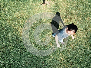 Aerial view of a young asian girl wearing glasses standing in the park.