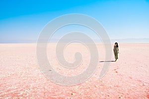 Aerial view young caucasian woman alone walk and explore maharlu salt lake in south Iran, Shiraz