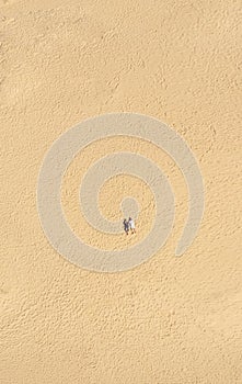 Aerial view of a young couple lying on the white sand. man and woman spend time together and travel through the desert