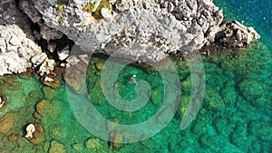Aerial view of a young couple snorkeling above coral reef reaching deeper parts of the crystal clear water, Rhodes, Greece. Aerial