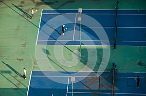 Aerial view of young people playing tennis on a winter afternoon