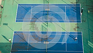 Aerial view of young people playing tennis on a winter afternoon