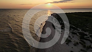 Aerial view of Young woman practicing yoga on the beach at sunset. Healthy active lifestyle concept.