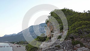 Aerial view of young woman on rock cliff against sea