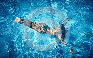 Aerial view of Young woman swimming underwater in the pool